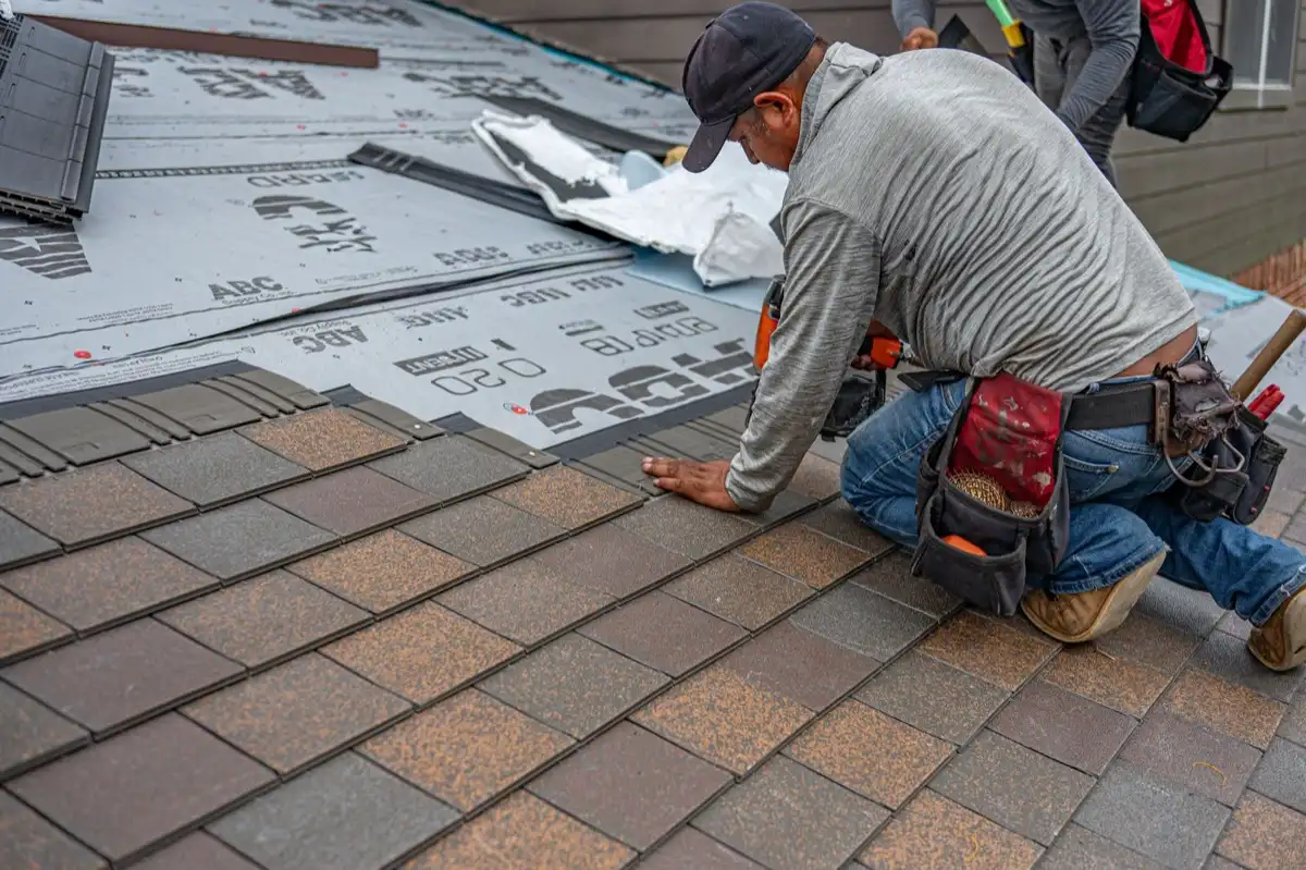 Roofing installer fastening shingles over new underlayment in Provo, UT
